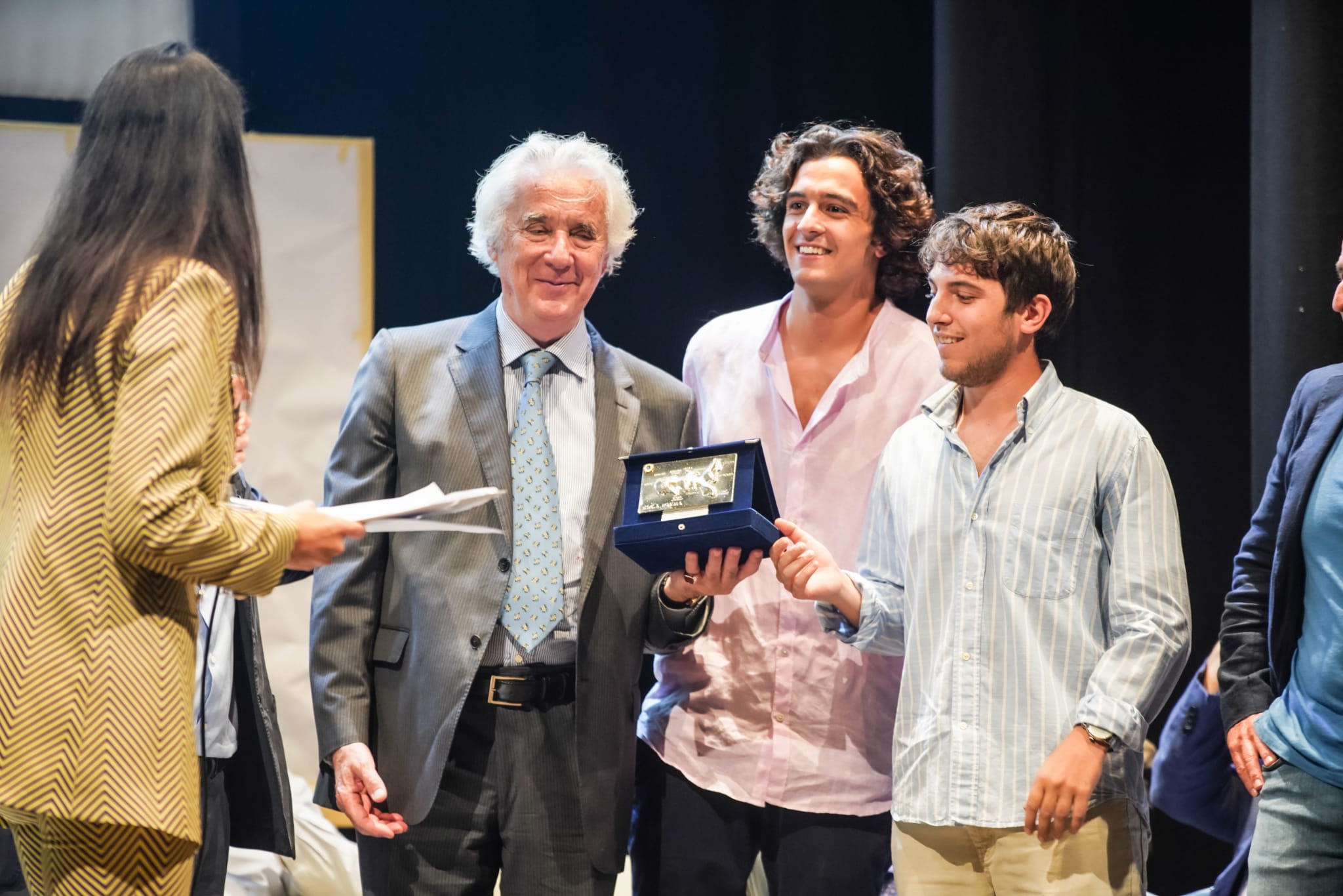 Roberto Bianchin riceve il Premio Isola d'Elba sul palco del Teatro dei Vigilanti di Portoferraio. A destra, i registi Michael Monni e Matteo Sardi. A sinistra, l'attrice Valeria Altobelli.